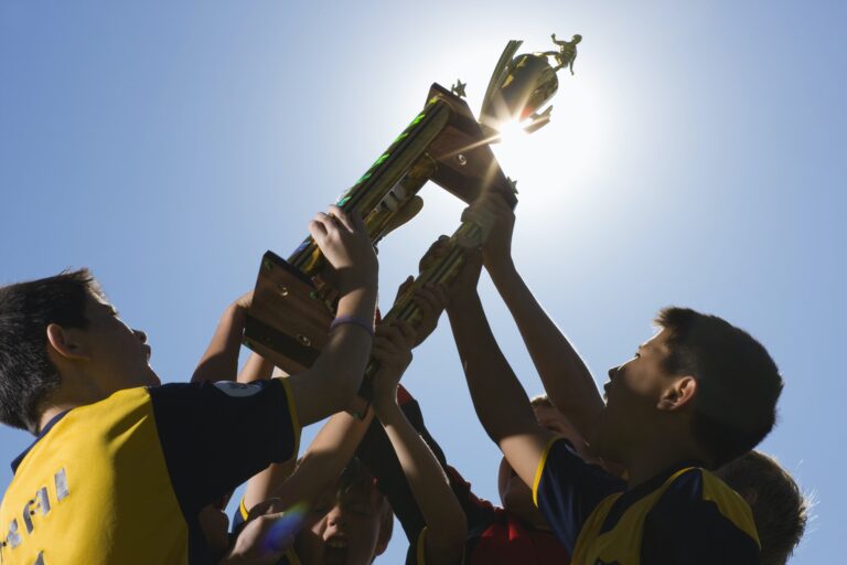 a-group-of-boys-in-soccer-team-shirts-holding-a-trophy-and-celebrating-a-win-.jpg